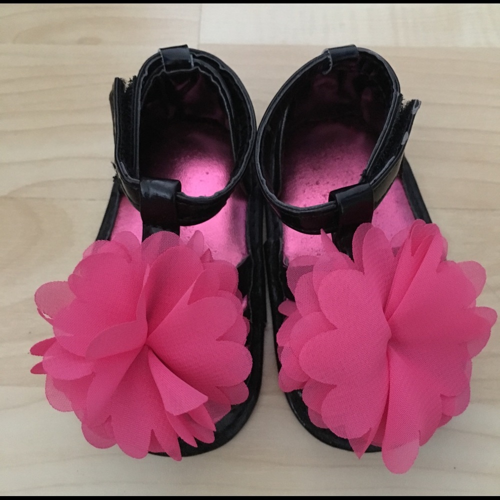 Adorable black sandals with a pink flower.